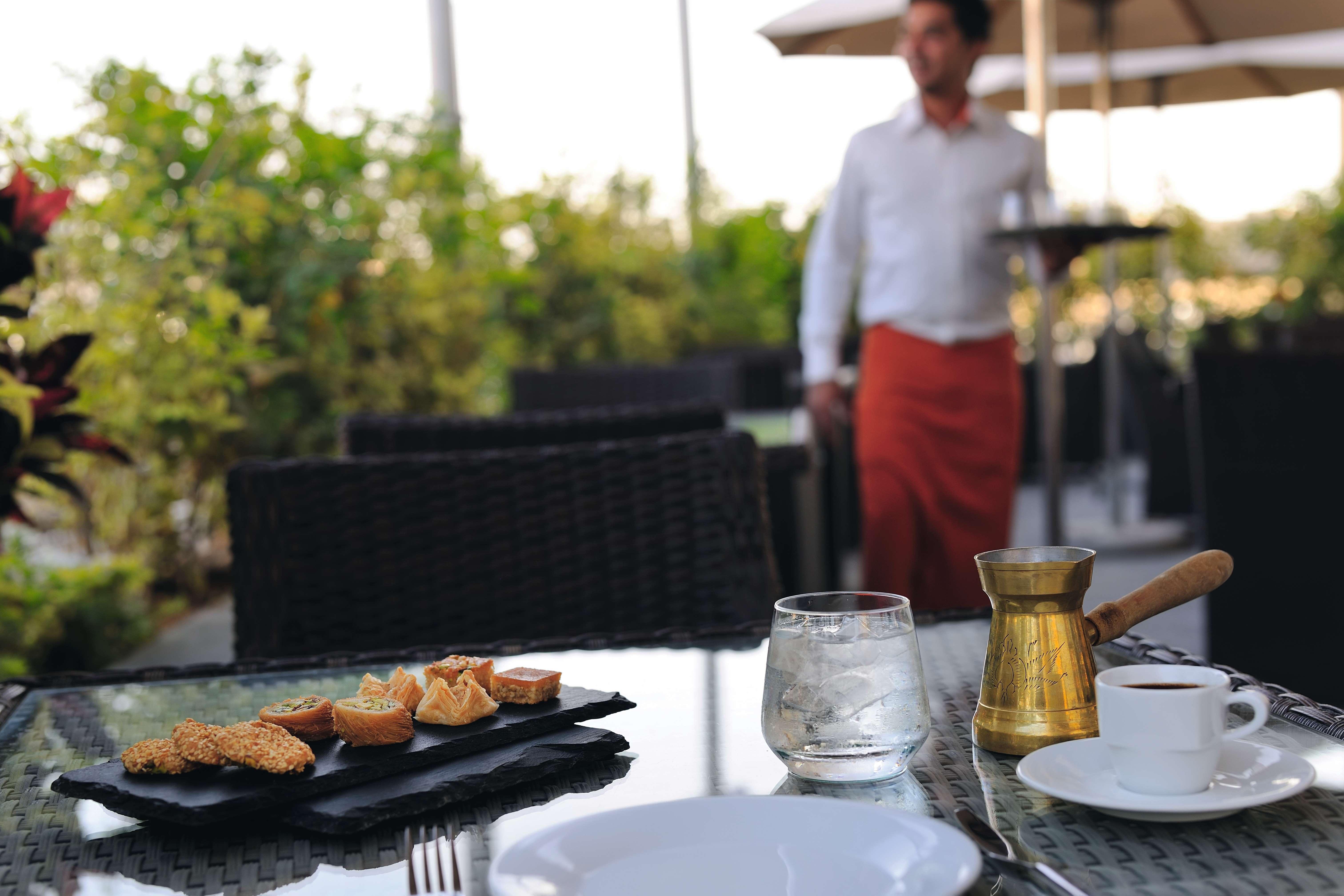Moevenpick Hotel Apartments Al Mamzar Dubai Esterno foto A waiter at work